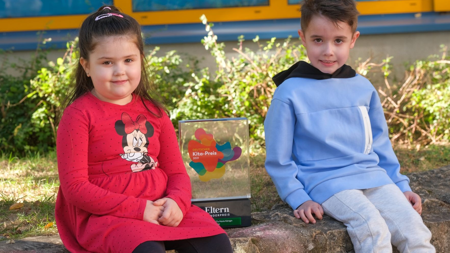Zwei Kinder mit der Trophäe des ELTERN-Sonderpreises